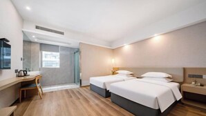 A hotel room with two beds, a desk, a chair, a nightstand, and a window. - yiduo hotel (Hangzhou)