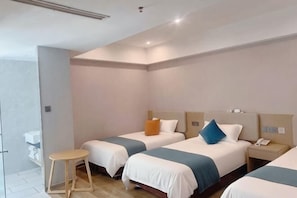 A hotel room with two beds, a bedside table, a small stool, and a bathroom with a toilet and sink. - yiduo hotel (Hangzhou)