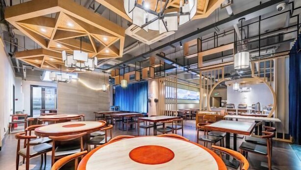 A modern interior with round tables, wooden chairs, and geometric ceiling designs. - yiduo hotel (Hangzhou)