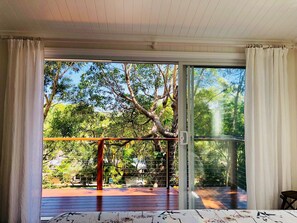 Une pièce dotée d’une grande porte-fenêtre coulissante donnant sur une terrasse extérieure.