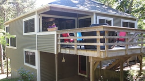 A two-story house with a deck, a garage, and a covered outdoor area. - Spacious and modern home, close to beach, Tom's Hill private setting. Home AC (Truro)
