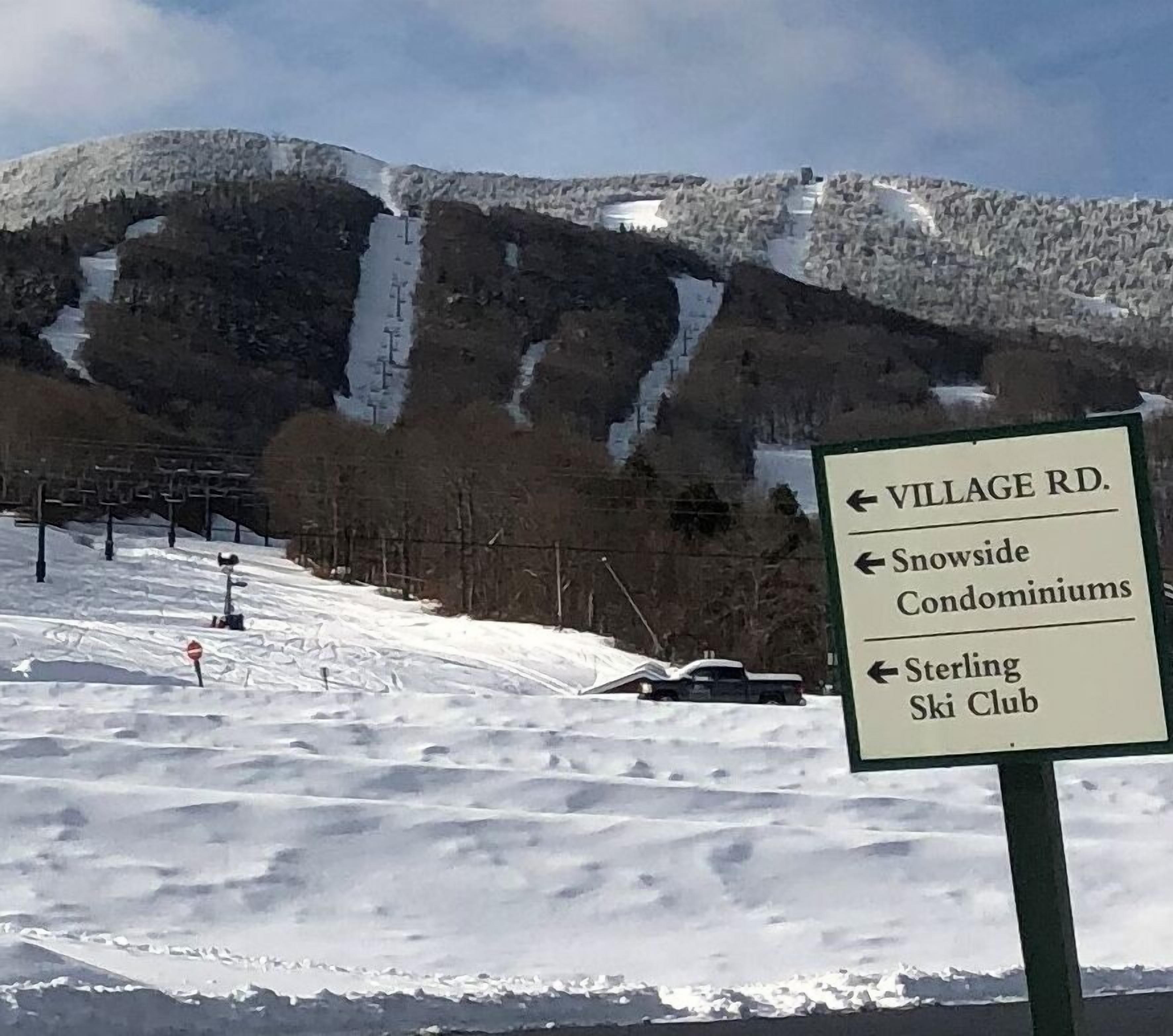 Señal con indicaciones hacia Village Rd., Snowside Condominiums y Sterling Ski Club.
