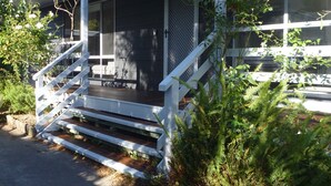 Ein Haus mit Veranda, Treppe und Zaun.