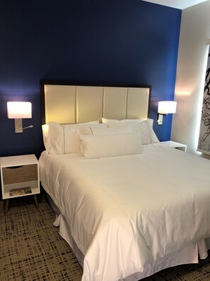 Relax in a spacious room with a large bed, two bedside tables, and a lamp on each.