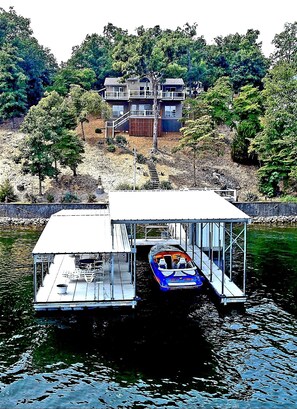 Une maison avec un quai et un bateau.