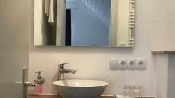 A bathroom with a white sink, a mirror, and a towel rack.