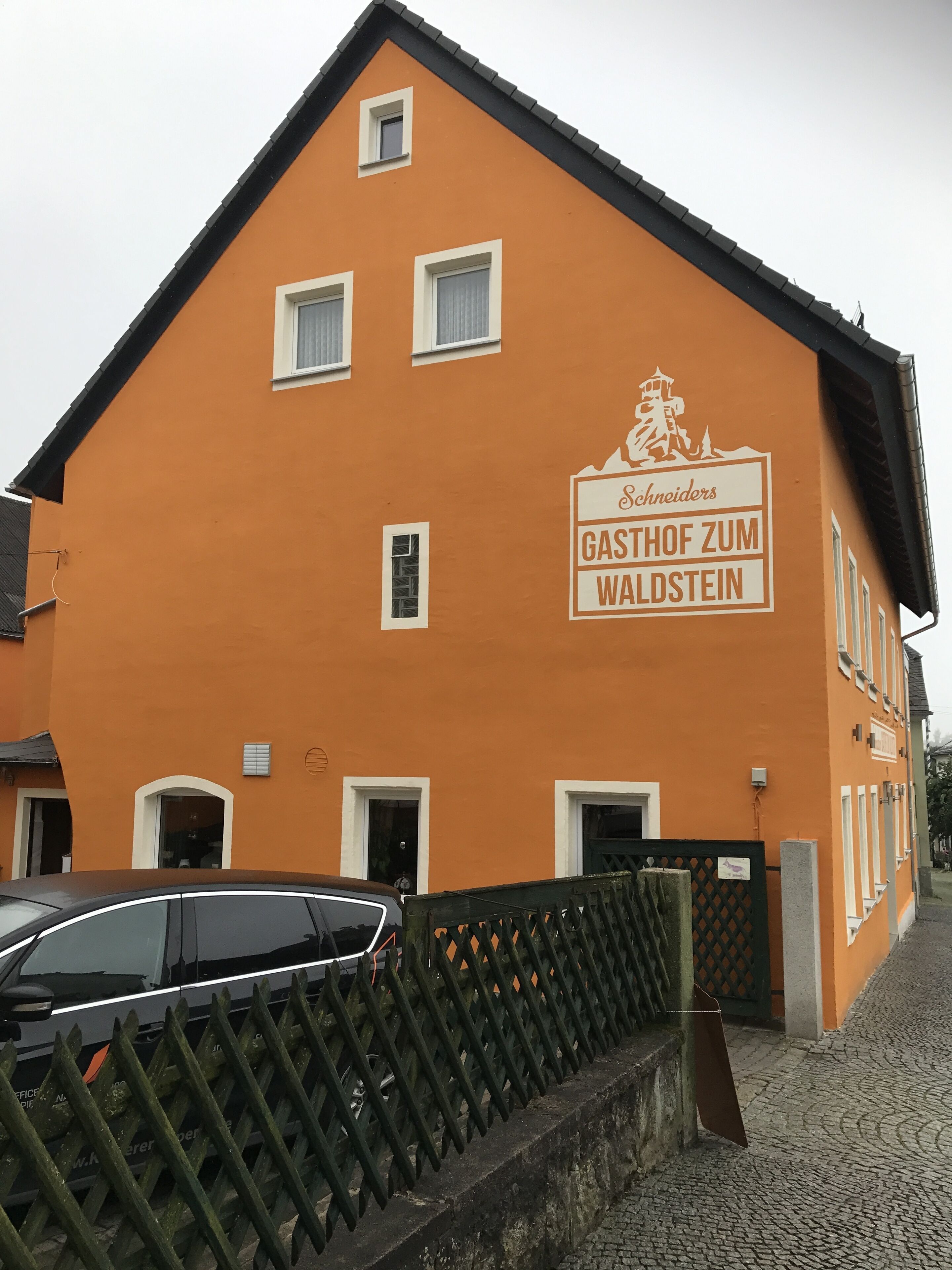 Un edificio con un letrero que dice "Schneiders Gasthof Zum Waldstein".
