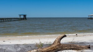 Une plage avec une structure en bois et un espace abrité.