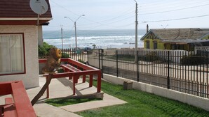 A seaside view with a bench and a fence overlooking the ocean.