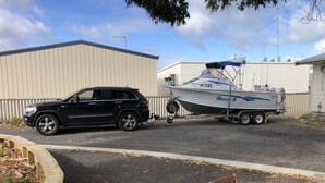 Un SUV noir remorquant un bateau sur une remorque.