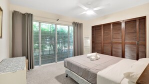 A bedroom with a bed, a ceiling fan, a window with curtains, and a sliding door with blinds. - Two bedroom unit in central location and only minutes walk to Deadmans... (Point Lookout)