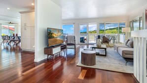 Uma sala de estar espaçosa com uma televisão grande, assentos confortáveis e uma varanda com vista panorâmica.