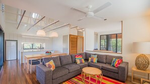 Una sala moderna con un sofá modular, un comedor y una cocina.