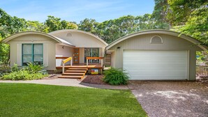 A modern house with a covered porch, a front door, and a garage. - 7 Belle Court - Rainbow Shores. Huge Beach House! Pets Welcome. Property not fenced. Ducted aircon (RAINBOW BEACH)