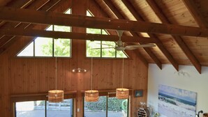 Un interno in legno con soffitto alto, ampie finestre e una ventola a soffitto.