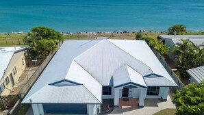 A modern house with a large garage, a covered patio, and a view of the ocean. - Seahaven - Located in Toogoom (TOOGOOM)