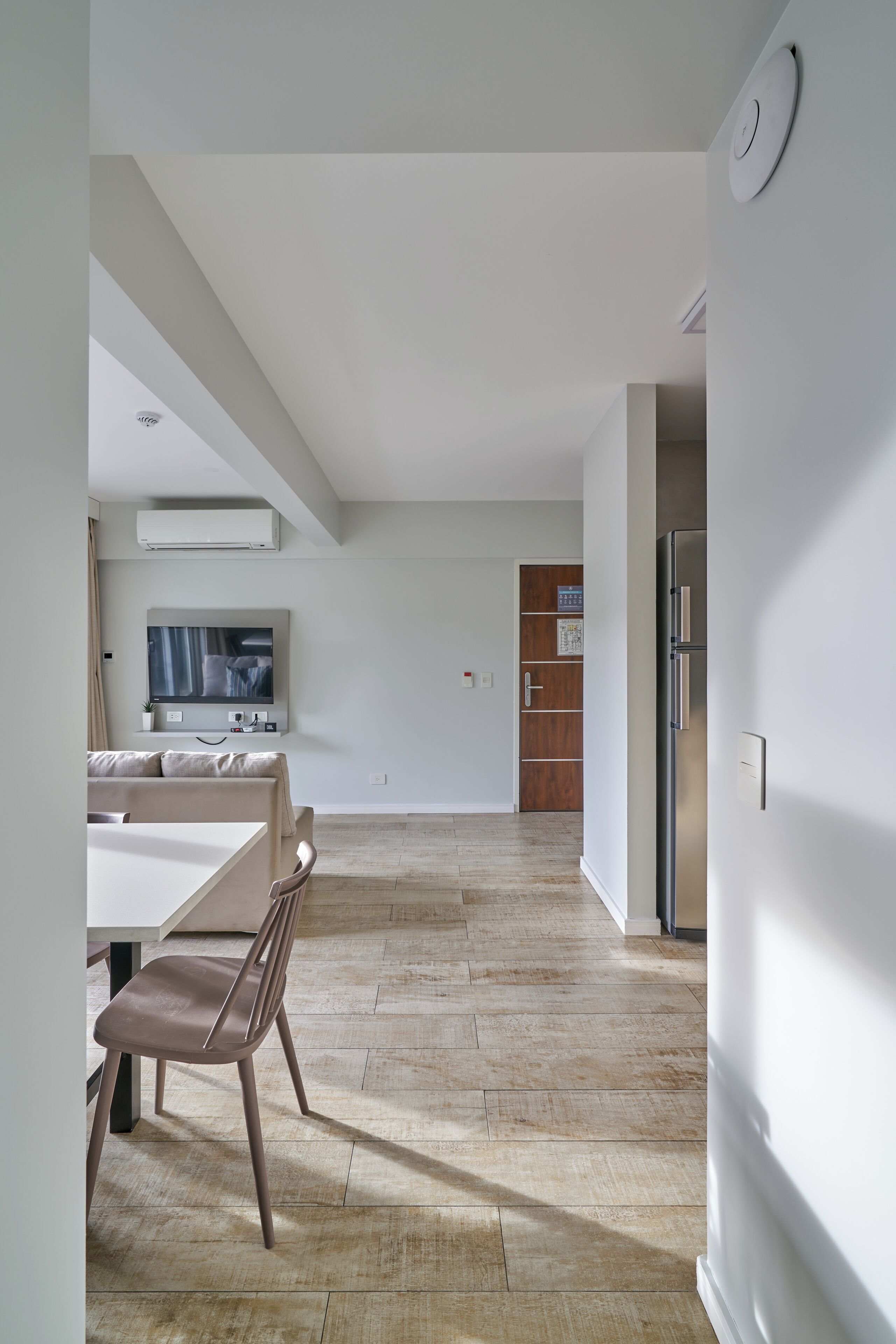 Una cucina moderna con forno integrato, frigorifero e porta in legno.