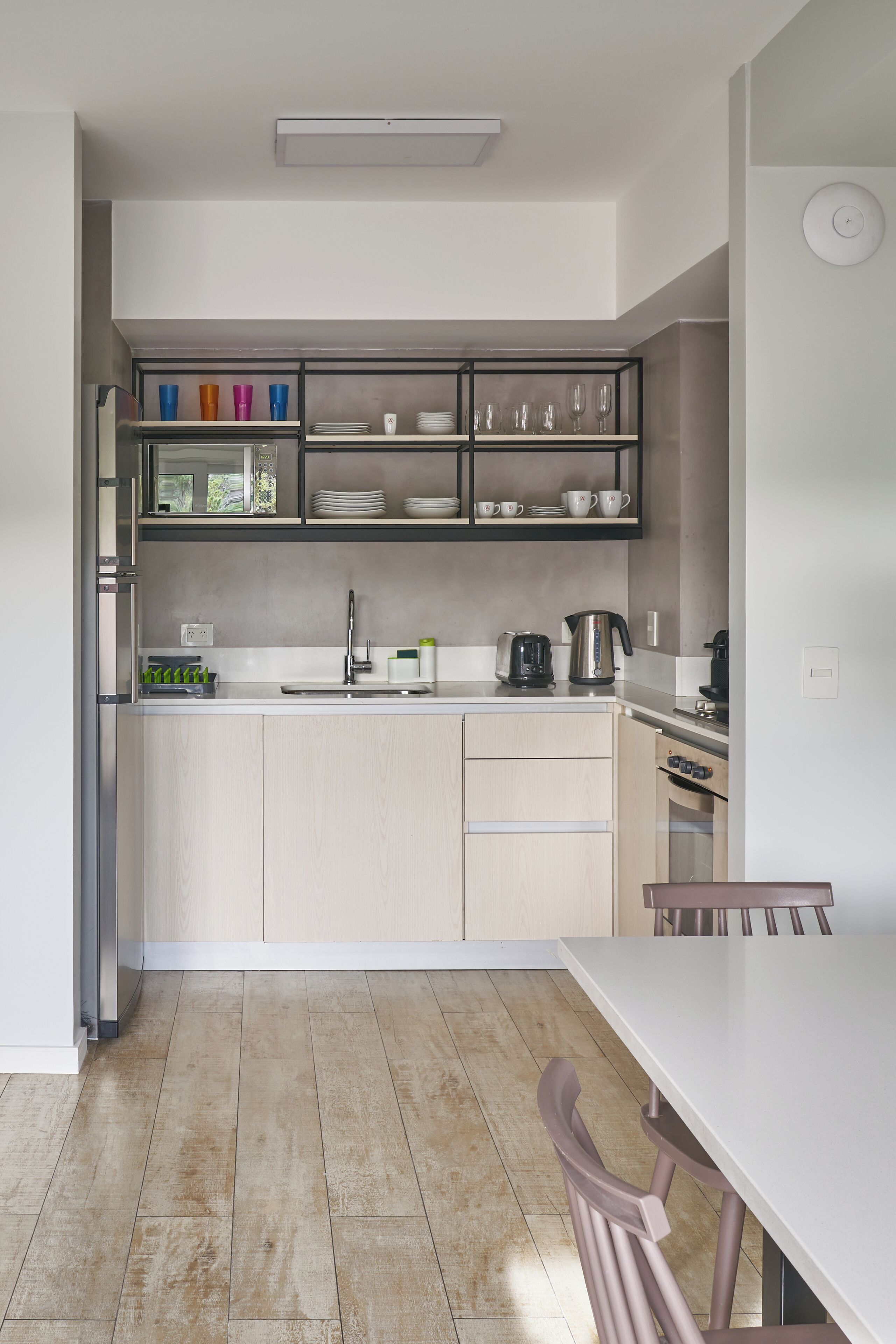 Eine moderne Küche mit Einbauofen, Spüle und Essbereich mit Tisch und Stühlen.