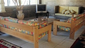 A living room with a sofa set, a television, and a coffee table.