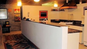 A kitchen with a central island, a microwave, and a red oven.