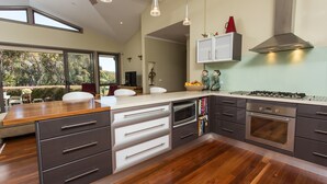 Una cocina moderna con una isla grande, electrodomésticos integrados y vistas al exterior.
