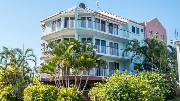 A multi-story building with balconies, surrounded by lush greenery. - Explorer Cove Unit 6, 31 Kennedy Pde (GOLDEN BEACH)