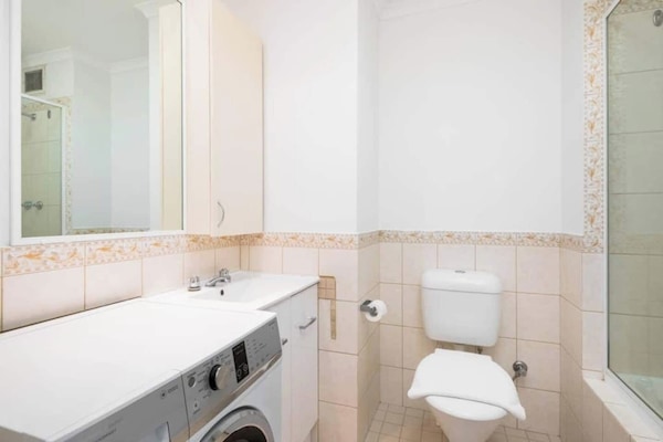 Enjoy the convenience of an in-unit washing machine and a shower over bath in this well-equipped bathroom with a toilet. Perfect for a comfortable and hassle-free stay.