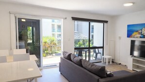 Una sala moderna con un sofá, una mesa de comedor y un televisor.