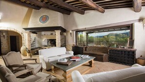 Un salon chaleureux avec une cheminée, des sièges confortables et une vue sur la campagne.