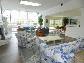 Relax in a spacious living area with a large window, comfortable seating, and a dining space.