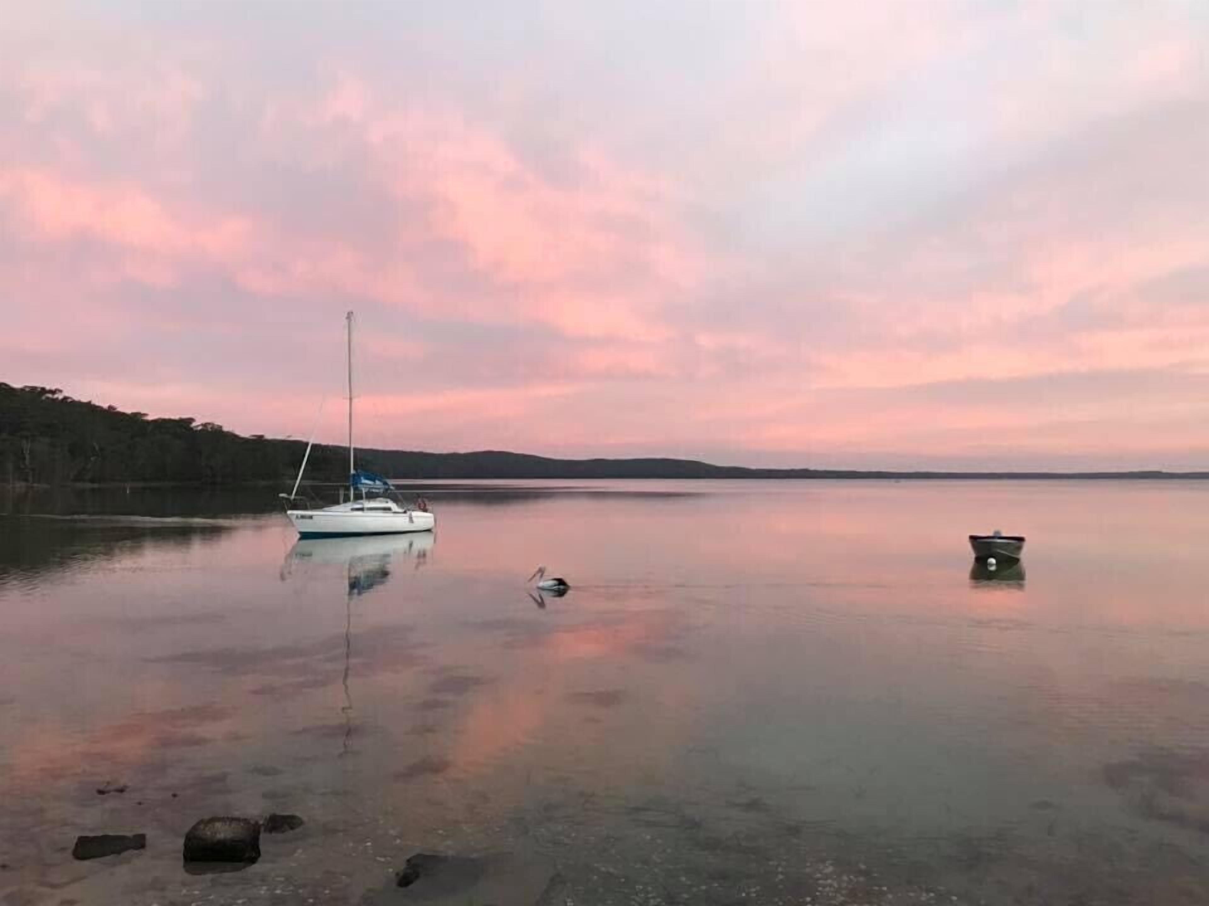 Un lago tranquillo con barche e un cielo sereno.