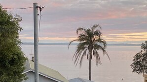 A residential area with a house, a garage, and a palm tree. - SeaEsta - Waterfront - Jervis Bay  - 5 minutes to Hyams Beach (Erowal Bay)