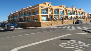 Een hotel met meerdere verdiepingen, gekenmerkt door een uniforme architectuur, met balkons en een gelijkmatige gevel.