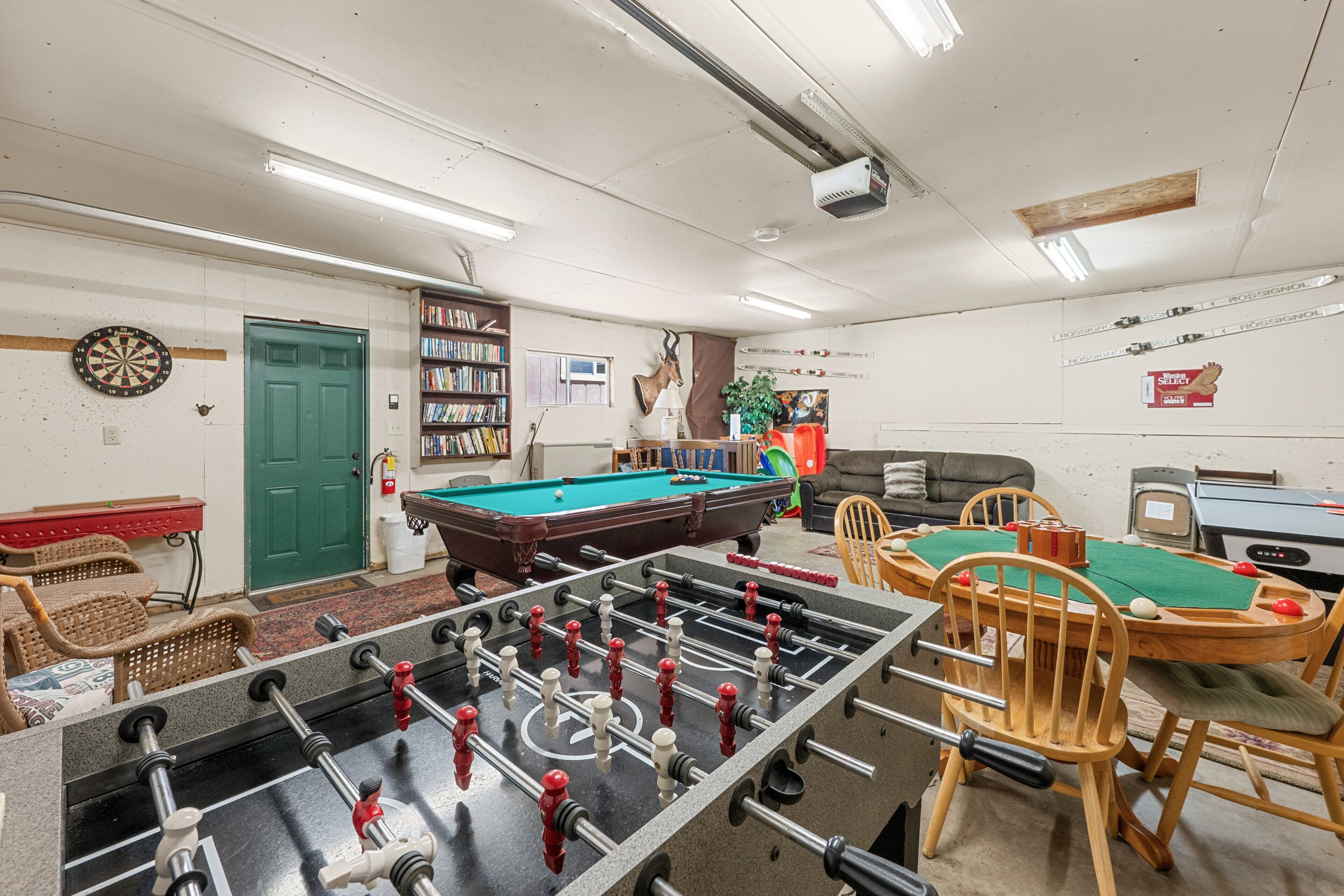 Ein Raum mit Kicker, Billardtisch und Dartscheibe.