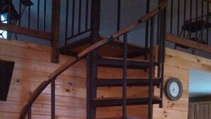 Eine hölzerne Wendeltreppe mit einer Holzkiste am Fuß.