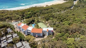Ein Resort mit mehreren Gebäuden, einem Swimmingpool und Blick auf den Strand.