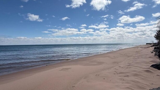 A beach with a clear sky and calm sea.
