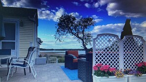 A patio with outdoor furniture, a tree, and a lattice fence. - Ocean view, FREE BEACH PASS. Short drive to multiple beaches and water park! (Fairhaven)