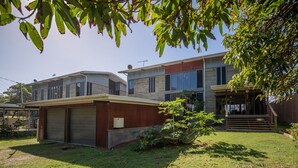Een tweelaags huis met een garage, een overdekte veranda en een verzorgd gazon.