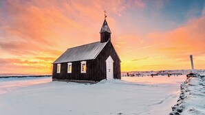 En trækirke med et kirketårn, omgivet af sne.