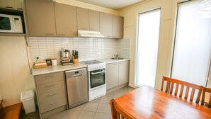 A compact kitchen with a microwave, espresso machine, sink, and oven. - ALLAMBIE COTTAGES - VILLA 2: Bright (Bright)