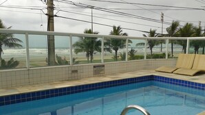 Une piscine avec vue sur la plage et les palmiers.