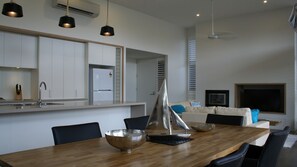 A modern kitchen with white cabinets, a stainless steel sink, and pendant lighting.
