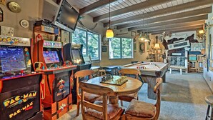 Een kamer met speelautomaten, een pooltafel en een gezellige zithoek.