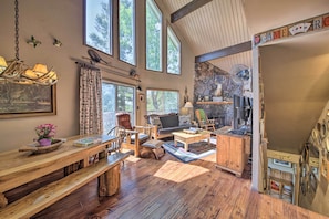 Relax in this inviting room with a high ceiling, large windows, and comfortable seating options.