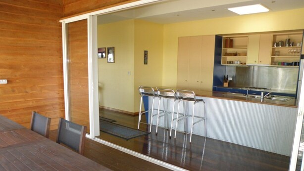 Eine moderne Küche mit Bar, Holzboden und Essbereich mit Tisch und Stühlen.