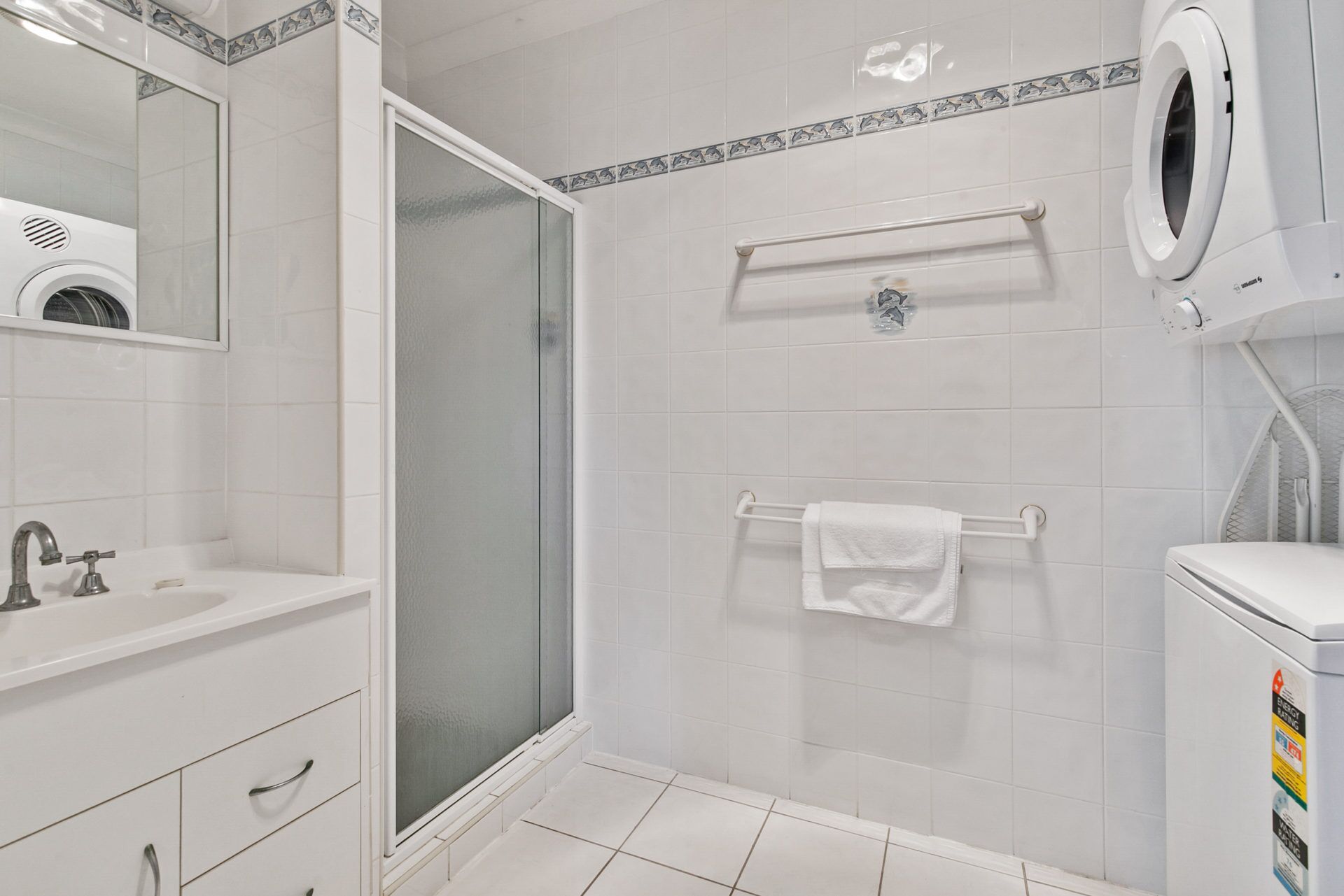 Ein modernes Badezimmer mit einer Glasdusche, einem weißen Waschbecken und einer Toilette.