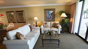 A living room with a sofa, a coffee table, and a painting on the wall. - Sanibel Harbour Resort Harbour Tower 716:          Private beach, heated pool, and grill (Fort Myers)