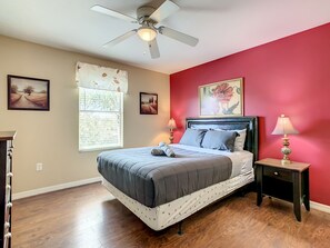 Cozy bedroom with a large bed, ceiling fan, and two bedside lamps.