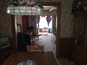 Relax in this inviting living room with a dining table, comfortable sofa, and wooden cabinet.